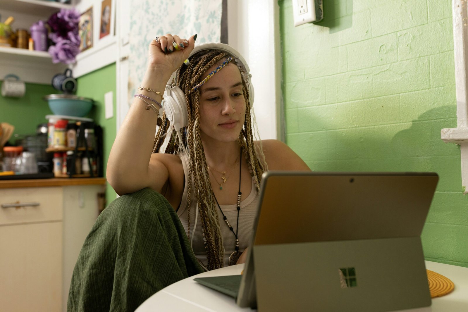 a woman with dreadlocks sitting in front of a laptop computer scaled